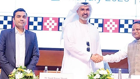 CM Mohan Charan Majhi shaking hand with IHC Group CEO Syed Basar Shueb after signing of MoU while Managing Director of Adani Ports Karan Adani looks on 