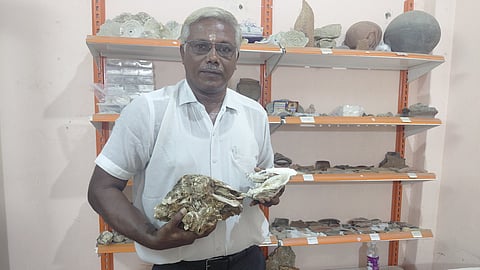 Rajesh Selvarathi holding the fossilised oyster shells.