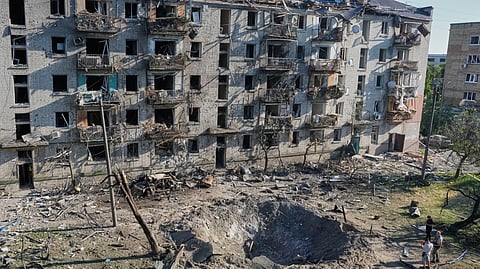 People look at the site of a Russian missile strike that hit a residential building in Kyiv, Ukraine, Thursday, July 2, 2026.
