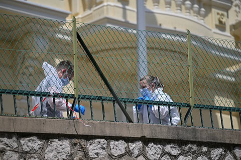 Investigators examine the scene at the residential building where an explosive devise seriously injured three people a day earlier in Monaco, Tuesday, June 30, 2026.