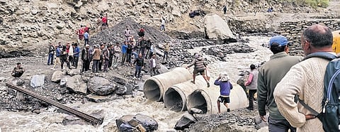 People cross a stream over concrete culvert pipes in Lahaul-Spiti on Friday
