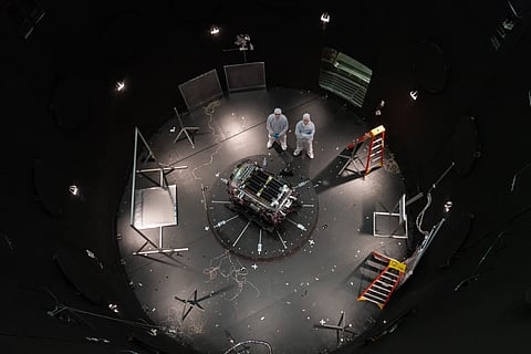 This photo provided by NASA shows Kieran Wilson, LINK’s principal investigator, and Hunter Robertson, a space systems engineer, both at Katalyst Space, standing next to their spacecraft inside the SES (Space Environment Simulator) at NASA’s Goddard Space Flight Center in Greenbelt, Md., April 17, 2026, ahead of thermal vacuum testing. 