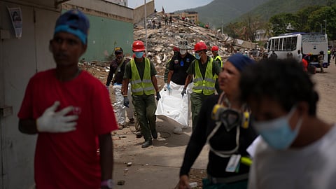 Rescue workers and forensic technician Joel Mirabal, back left, recover the body of an earthquake victim in La Guaira, Venezuela, Tuesday, June 30, 2026.