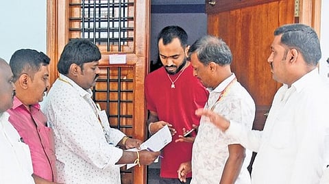 Booth level officers distribute SIR enumeration forms to a resident in Bengaluru.