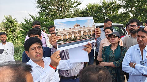 Locals and officials showing the design of the temple and vacant land at the site.