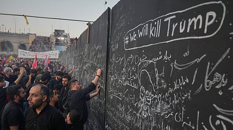 Mourners write messages on a wall, including one in English that reads "We will kill Trump," during the funeral ceremonies for slain Iranian Supreme Leader Ayatollah Ali Khamenei and members of his family at the Imam Khomeini Mosalla Grand Mosque in Tehran, Iran, Saturday, July 4, 2026.