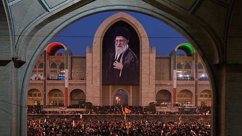 Mourners gather beneath a portrait of the late Iranian Supreme Leader Ayatollah Ali Khamenei during the funeral ceremonies for Khamenei and members of his family at the Imam Khomeini Mosalla Grand Mosque in Tehran, Iran, Saturday, July 4, 2026.