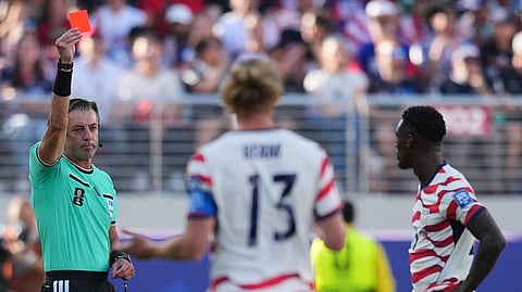Referee Raphael Claus of Brazil shows a red card to United States' Folarin Balogun, right, during the World Cup round of 32 soccer match between the United States and Bosnia in Santa Clara, Calif., near San Francisco, Wednesday, July 1, 2026. 