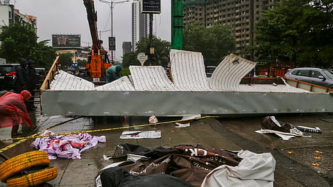 A hoarding lies damaged after strong winds uproot it from a road divider on Pokhran Road amid heavy rainfall, in Thane, Maharashtra, Monday, July 6, 2026