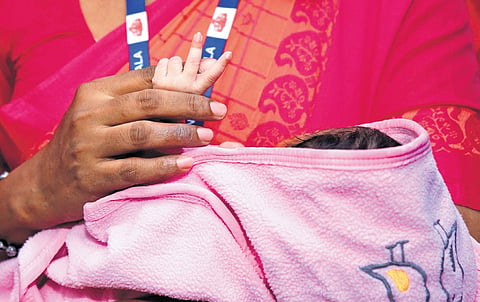 A CWC official carrying the infant after he was discharged from the special newborn care unit of Ernakulam General Hospital on Monday  