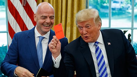 President Donald Trump holds up a red card during a meeting with FIFA president Gianni Infantino in the Oval Office of the White House.