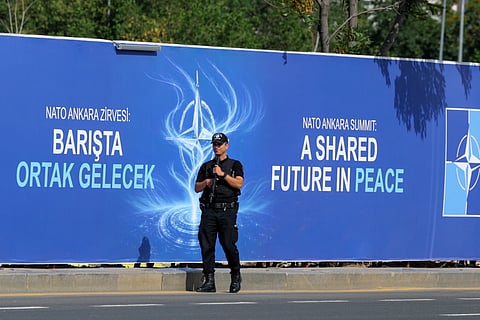 Police patrol in front of a banner ahead of the NATO Summit in Ankara, Turkey, Sunday, July 5, 2026. 