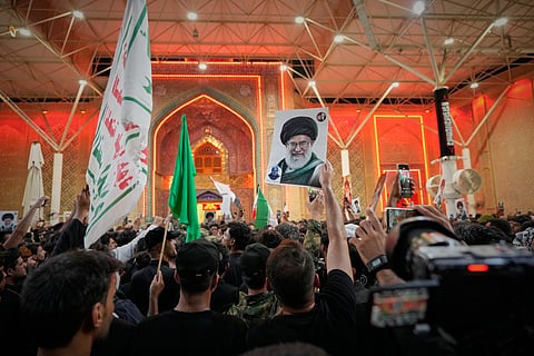 Mourners wave Shiite religious flags and a portrait of the late Iranian Supreme Leader Ayatollah Ali Khamenei outside the Imam Ali Shrine on the eve of funeral ceremonies in Najaf, Iraq, Tuesday, July 7, 2026. 