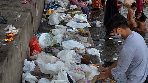 Puja offerings thrown by devotees in the Yamuna river, after the end of Navratri festival, at Wazirabad Yamuna ghat, in New Delhi, Sunday,