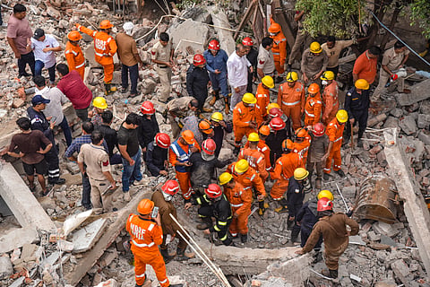 NDRF and other personnel conduct a rescue operation at the site after a four-storey building collapsed at Rohini.