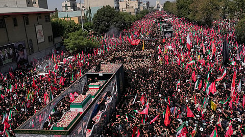 The truck carrying the coffins of the slain Iranian Supreme Leader Ayatollah Ali Khamenei and members of his family makes its way through mourners during the funeral procession toward Azadi Tower in Tehran, Iran, Monday, July 6, 2026.