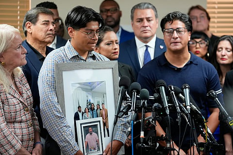 Ronaldo Salgado, right, son of Lorenzo Salgado Araujo, speaks as his brother, Lorenzo Jr. holds family photographs during a news conference Wednesday, July 8, 2026, in Houston.