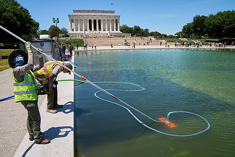 Members of the National Park Service clean algae from the Lincoln Memorial Reflecting Pool