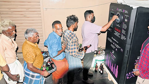 Customers use an empty bottle return machine at a Tasmac  outlet; (inset) the model of the machine