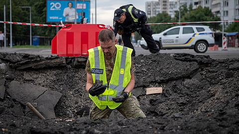 A sapper examines the impact site of a Russian missile in a residential area of Kyiv, Saturday, July 11, 2026. 