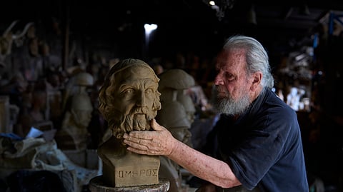 Sculptor and ceramicist Haralambos Goumas works on a terracotta bust of the ancient Greek poet Homer, the author of the Iliad and the Odyssey, at his workshop in the Athens suburb of Aigaleo, Wednesday, May 27, 2026. 