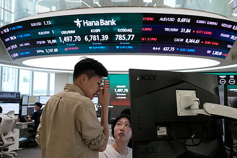 Currency traders work at the foreign exchange dealing room of the Hana Bank headquarters in Seoul, South Korea, Tuesday, July 14, 2026. 