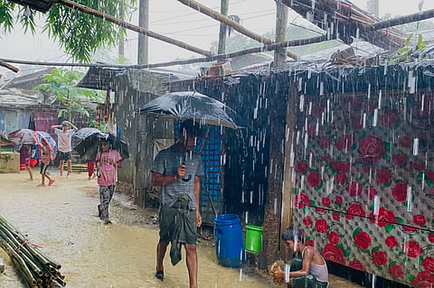 People walk through heavy rain at a Rohingya refugee camp in Cox's Bazar, Bangladesh, Tuesday, July 7, 2026. 