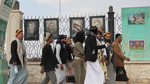 Houthi supporters walk in front of posters of some top Iranian scientists who have been killed in Israeli strikes in Sanaa, Yemen, on Monday, July 13, 2026.