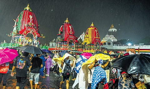 With incessant rain lashing Puri, devotees throng Singhadwar to have a glance at chariots of the Holy Trinity on the eve of annual Rath Yatra on Wednesday 