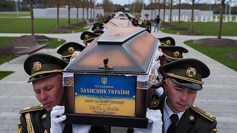 An honor guard carries the coffins of unidentified Ukrainian soldiers killed in battle during the Russian-Ukrainian war at a funeral ceremony at a military cemetery near Kyiv, Ukraine, April 30, 2026.