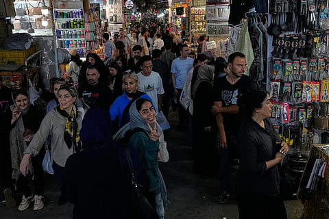 A woman flashes a victory sign while walking at Tehran's traditional main bazaar, Iran, Thursday, July 16, 2026.