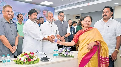 Deputy Chief Minister Mallu Bhatti Vikramarka and Health Minister Damodar Rajanarsimha hand over a new health card to an employee in Hyderabad on Friday