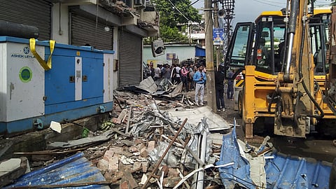 Debris lies scattered beside an excavator amid the demolition of the party office of Trinamool Congress MP Abhishek Banerjee aft