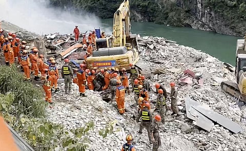 In this photo taken from video, rescuers pull a person out from the rubble after a landslide buried residential buildings in Pengshui County in southwestern China's Chongqing on Friday, July 17, 2026.