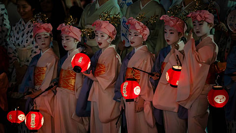 Young women dressed in traditional attire take part in the "Mikoshi Arai" purification ritual ahead of the Gion Matsuri festival in Kyoto, western Japan, Friday, July 10, 2026.