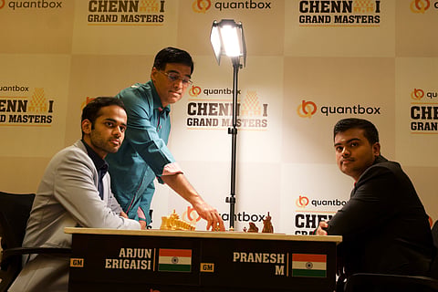 Viswanathan Anand (C) makes his first move on Arjun Erigaisi and Pranesh M's game on Sunday