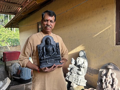 Ganesh Bhat holding a Buddha 