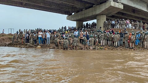 Security personnel interact with people at the banks of the Barana river as the 15-day protest against the Ken-Betwa Link and other development projects ended after police cleared the agitation site, in Chhatarpur district, Madhya Pradesh, Sunday, July 19, 2026.