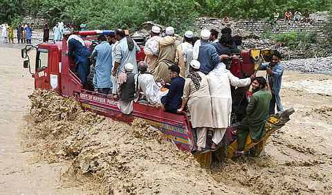 People ride a truck as they wade through floodwater following heavy monsoon rains at Landi Kotal in Pakistan’s Khyber Pakhtunkhwa province on July 20, 2026.