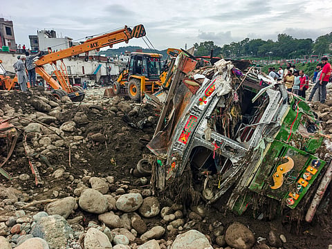 Damaged vehicles lie in a debris-strewn area following landslides and heavy rain, in Rajouri, Jammu and Kashmir, Monday, July 20, 2026