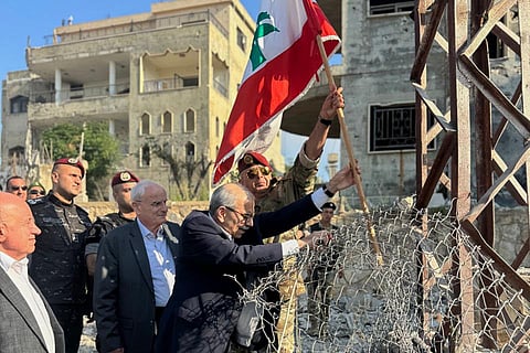 In this photo released by the Lebanese Government press office, Lebanese Prime Minister Nawaf Salam, center, raises a Lebanese flag during a visit to the southern village of Zawtar Al Gharbieh, Lebanon, Wednesday, July 22, 2026.