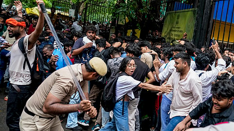 Police personnel stop Cockroach Janata Party (CJP) supporters as they raise slogans during a protest march at Sansad Marg, in New Delhi, on Monday, July 20, 2026. 