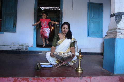 A women reading Ramayana in her house