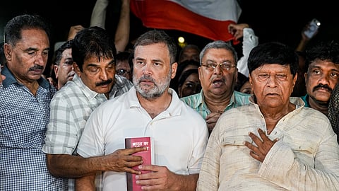 Lok Sabha LoP Rahul Gandhi holds a copy of the Constitution of India, as he along with opposition MPs sings the national anthem at the Gandhi Smriti, in New Delhi.