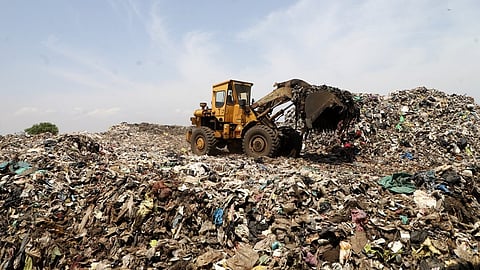Workers transport legacy waste to the bio-mining facility at the Vellalore dumpyard in Coimbatore. 