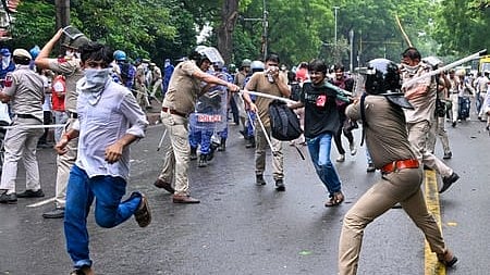 Protesters run from Delhi Police personnel during their protest at Jantar Mantar, New Delhi.