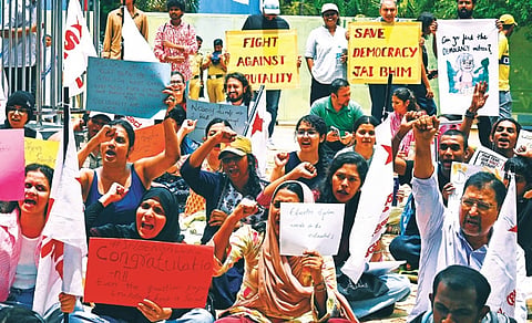 Protesters demand the resignation of Union Education Minister Dharmendra Pradhan at Freedom Park in Bengaluru on Friday.