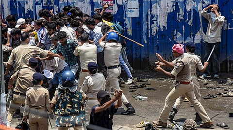 Security personnel try to evict protesters during the 'Bihar Bandh' called over the alleged NEET paper leak and police action against protesting students, at Ram Gulam Chowk, in Patna, Bihar, Saturday, July 25, 2026.