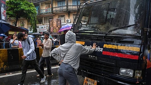 Rhiya Ahir, a model, blocks a police van carrying detained protesters during a demonstration demanding educational reforms as part of the Cockroach Janta Party’s ongoing protest movement in Mumbai, India, Wednesday, July 22, 2026. 