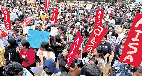 Volunteers celebrate the resignation of former Union Minister Dharmendra Pradhan, over the NEET issue, at Freedom Park in Bengaluru on Sunday